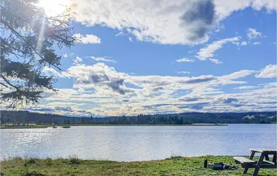 a picnic table on the shore of a lake at 3 Bedroom Awesome Home In Svingvoll in Svingvoll