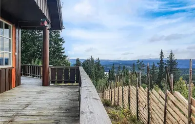 a wooden walkway to a house with a view of the mountains at 3 Bedroom Awesome Home In Svingvoll in Svingvoll