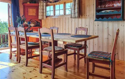 a kitchen with a wooden table and chairs at 3 Bedroom Awesome Home In Svingvoll in Svingvoll