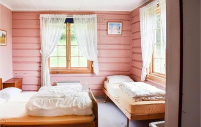 two beds in a room with pink walls and windows at 10 Bedroom Lovely Home In Østre Gausdal in Vestre Gausdal