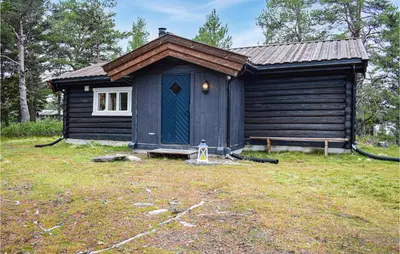 a small cabin with a blue door in a yard at Nice Home In Kvam With Kitchen in Kvam