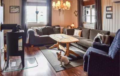 a dog standing in a living room with a table at Awesome Home In Nord-Torpa With Kitchen in Nord Torpa