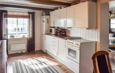 a kitchen with white cabinets and a stove at Awesome Home In Nord-Torpa With Kitchen in Nord Torpa