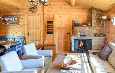 a living room with a fireplace in a log cabin at 4 Bedroom Stunning Home In Vinstra in Vinstra