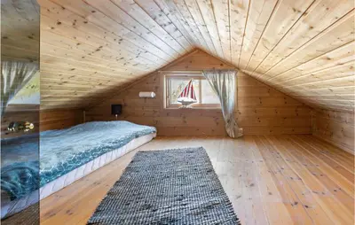 a bedroom in a log cabin with a bed and a window at Gorgeous Home In Øyer With Sauna in Øyer