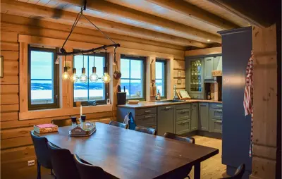 a kitchen with a wooden table and a dining room at Beautiful Home In Øyer With Sauna in Øyer