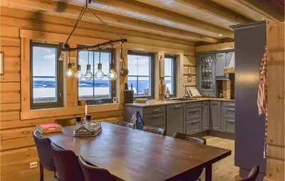 a dining room with a table and some windows at Beautiful Home In Øyer With Sauna in Øyer