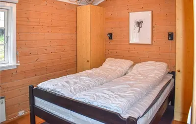 a bed in a room with a wooden wall at Amazing Home In Øyer With Kitchen in Øyer