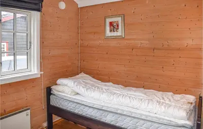 a bedroom with a bed in a wooden wall at Amazing Home In Øyer With Kitchen in Øyer