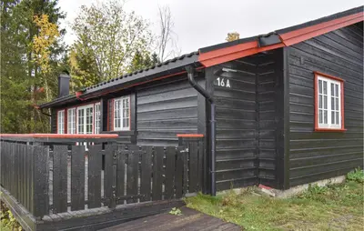 a black house with a fence in front of it at Amazing Home In Øyer With Kitchen in Øyer
