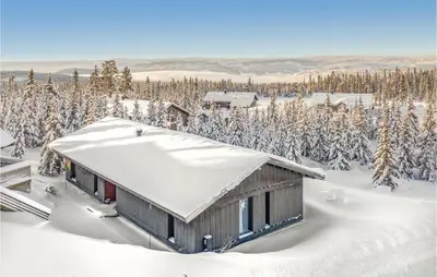 a cabin in the snow with snow covered trees at Beautiful Home In Øyer With Sauna in Øyer