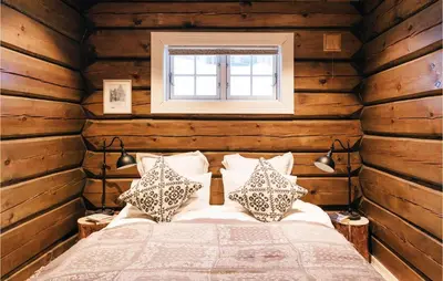 a bedroom with a bed in a room with wooden walls at Solbergsætra in Øyer