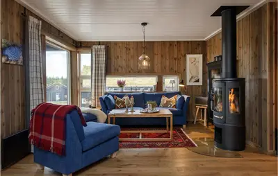 a living room with a blue couch and a fireplace at Gorgeous Home In Sjusjøen With Kitchen in Sjusjøen
