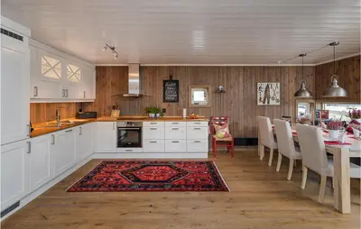 a kitchen with white cabinets and a table with chairs at Gorgeous Home In Sjusjøen With Kitchen in Sjusjøen