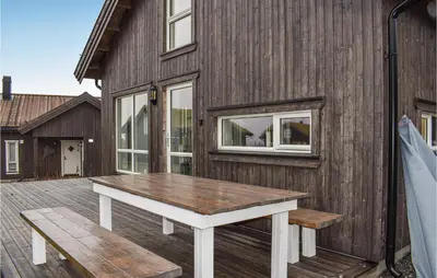 a wooden building with a picnic table on a deck at 4 Bedroom Stunning Home In Øyer in Øyer