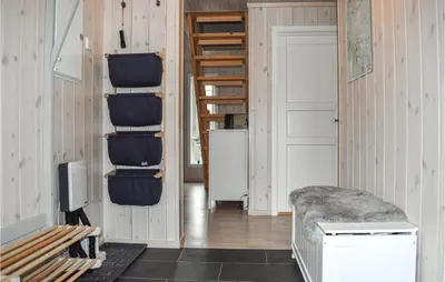 a room with wooden walls and a stairway with chairs at 4 Bedroom Stunning Home In Øyer in Øyer