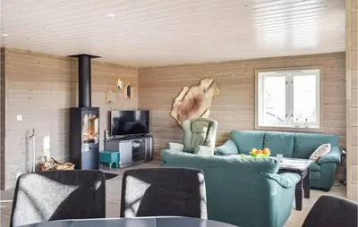a living room with blue furniture and a fireplace at 3 Bedroom Amazing Home In Sjusjøen in Sjusjøen