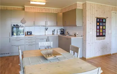 a kitchen with a wooden table and a wooden floor at Nice Home In Sjusjøen With Kitchen in Sjusjøen