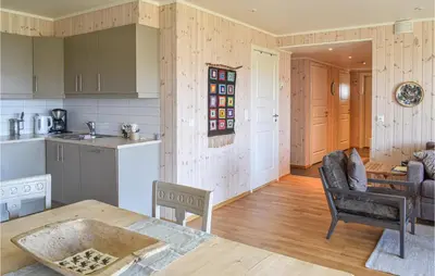 a kitchen and living room with a table and chairs at Nice Home In Sjusjøen With Kitchen in Sjusjøen