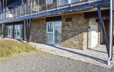 a brick building with a balcony on the side of it at Nice Home In Sjusjøen With Kitchen in Sjusjøen