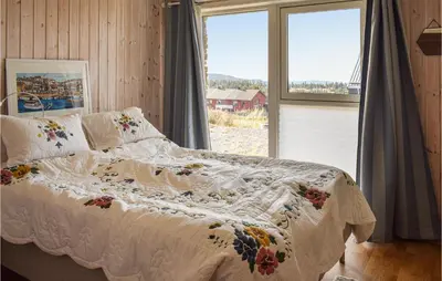 a bed with a white comforter and a window at Nice Home In Sjusjøen With Kitchen in Sjusjøen