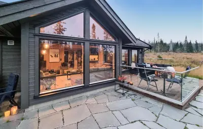 a house with large glass windows and a patio at Lovely Home In Lillehammer With Kitchen in Lillehammer