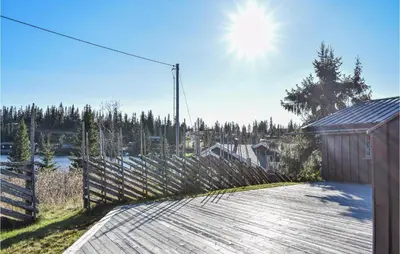 a house with a wooden deck and a fence at Sjusjøen Pihl 4001 in Sjusjøen