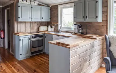 a kitchen with white cabinets and a counter top at Cozy Home In Sjusjøen in Sjusjøen