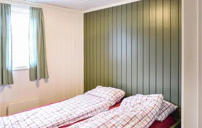 two beds in a room with green walls and a window at Cozy Home In Sjusjøen in Sjusjøen