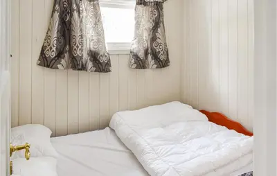 a bed in a corner of a room with a window at 4 Bedroom Nice Home In Sjusjøen in Sjusjøen