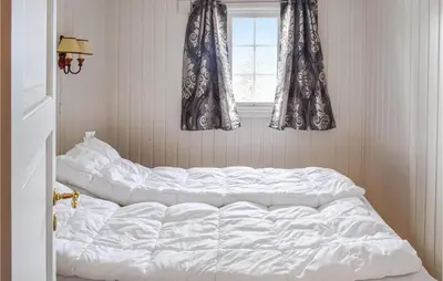 a white bed in a room with a window at 4 Bedroom Nice Home In Sjusjøen in Sjusjøen