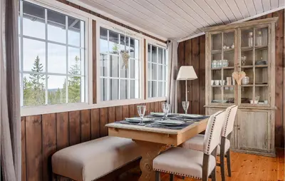 a dining room with a table and chairs and windows at 4 Bedroom Gorgeous Home In Sjusjøen in Sjusjøen