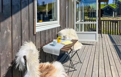 two dogs sitting around a table on a deck at 4 Bedroom Amazing Home In Lillehammer in Lillehammer