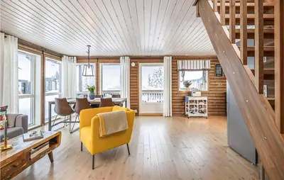 a living room with a yellow chair and a table at 4 Bedroom Amazing Home In Lillehammer in Lillehammer
