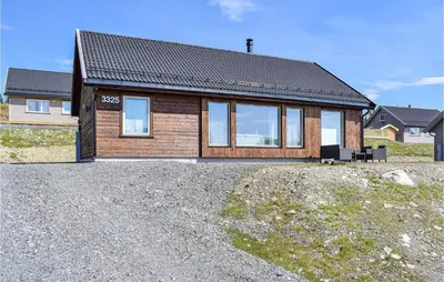 a house sitting on top of a gravel lot at 4 Bedroom Cozy Home In Sjusjøen in Sjusjøen