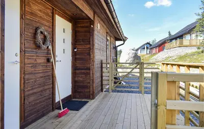 a wooden barn door with a mop on a porch at 4 Bedroom Cozy Home In Sjusjøen in Sjusjøen