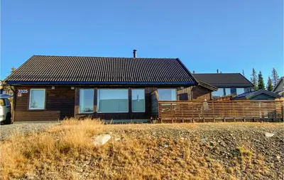 a wooden house with a fence in front of it at 4 Bedroom Cozy Home In Sjusjøen in Sjusjøen