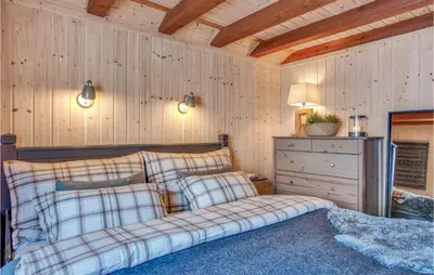 a bedroom with a bed and a dresser in a room at Nice Home In Reinli With Kitchen in Reinli