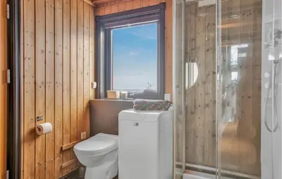 a bathroom with a toilet and a window at Nice Home In Reinli With Kitchen in Reinli