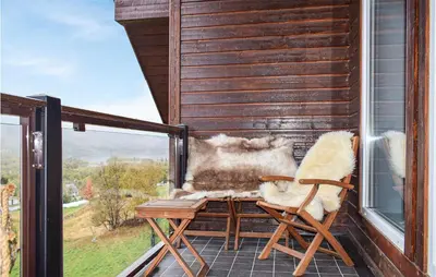 a balcony with two chairs and a table and a window at 2 Bedroom Cozy Apartment In Geilo in Geilo