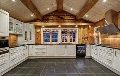 a large kitchen with white cabinets and wooden ceilings at Gorgeous Home In Lampeland With Kitchen in Lampeland