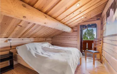 a bedroom with a bed in a wooden cabin at Gorgeous Home In Lampeland With Kitchen in Lampeland