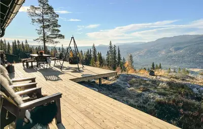 a wooden deck with a table and a swing at 3 Bedroom Awesome Home In Eggedal in Eggedal