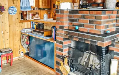 a fireplace in a living room with a brick wall at Stunning Home In Uvdal With Wifi in Uvdal