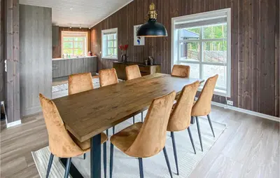 a dining room with a wooden table and chairs at Beautiful Home In Rødberg in Rødberg