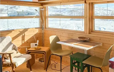 a room with windows and a table and chairs at 1 Bedroom Nice Home In Geilo in Geilo