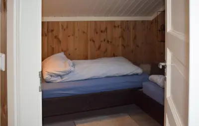 a small bed in a room with wooden walls at 4 Bedroom Awesome Home In Eggedal in Eggedal