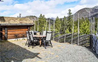a table and chairs sitting on the side of a cabin at Lovely Home In Hemsedal With Wifi in Hemsedal