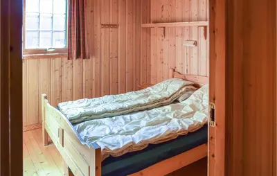 a bunk bed in a wooden room with a window at Bjertnes Turistgård in Noresund