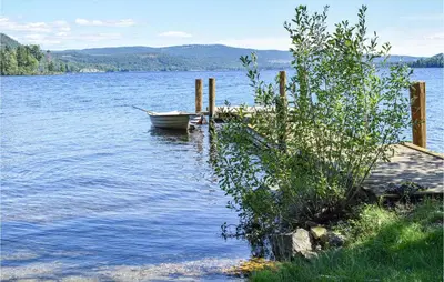 a boat sitting in the water next to a dock at Bjertnes Turistgård in Noresund